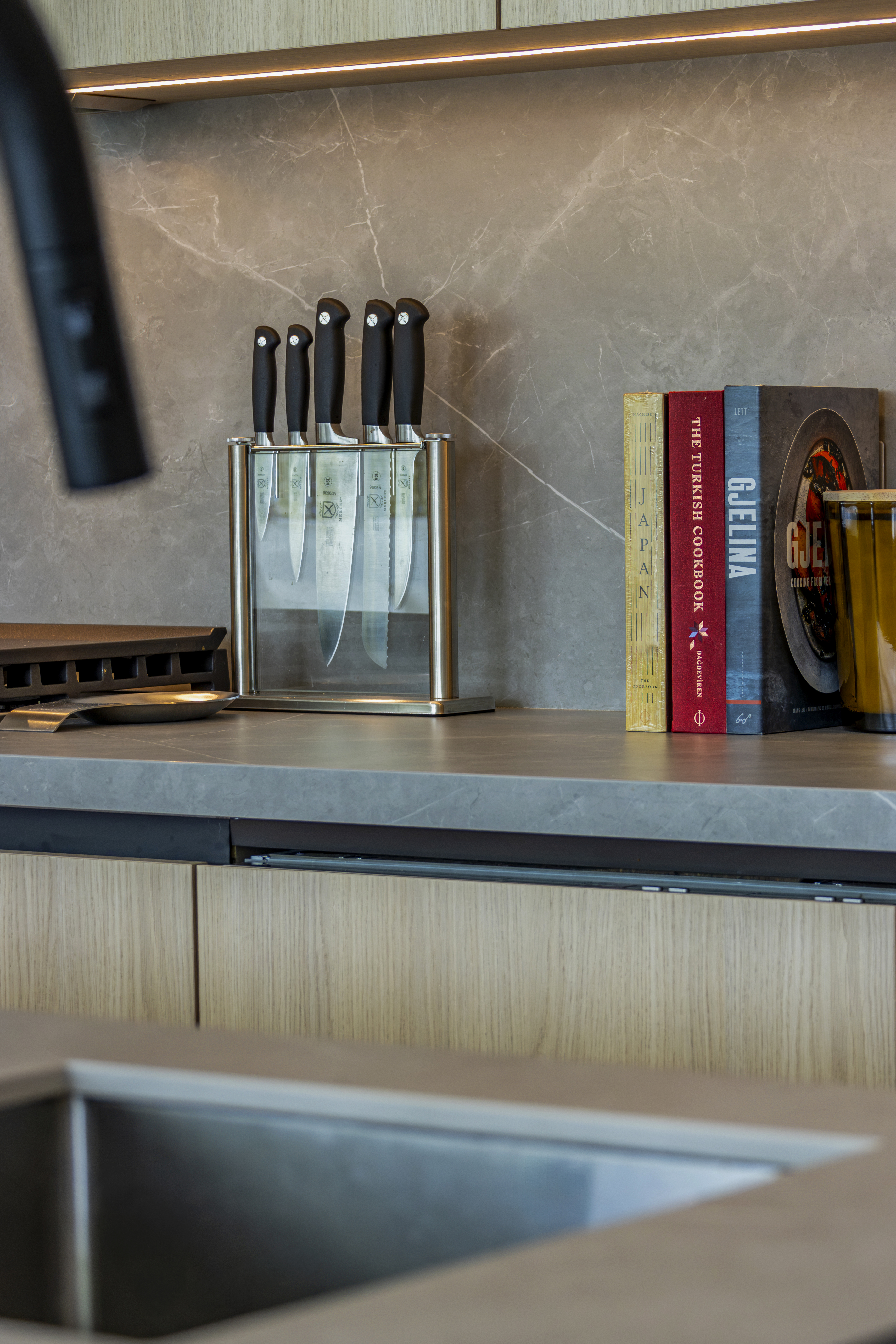Kitchen — stone backsplash with knife block and cookbooks