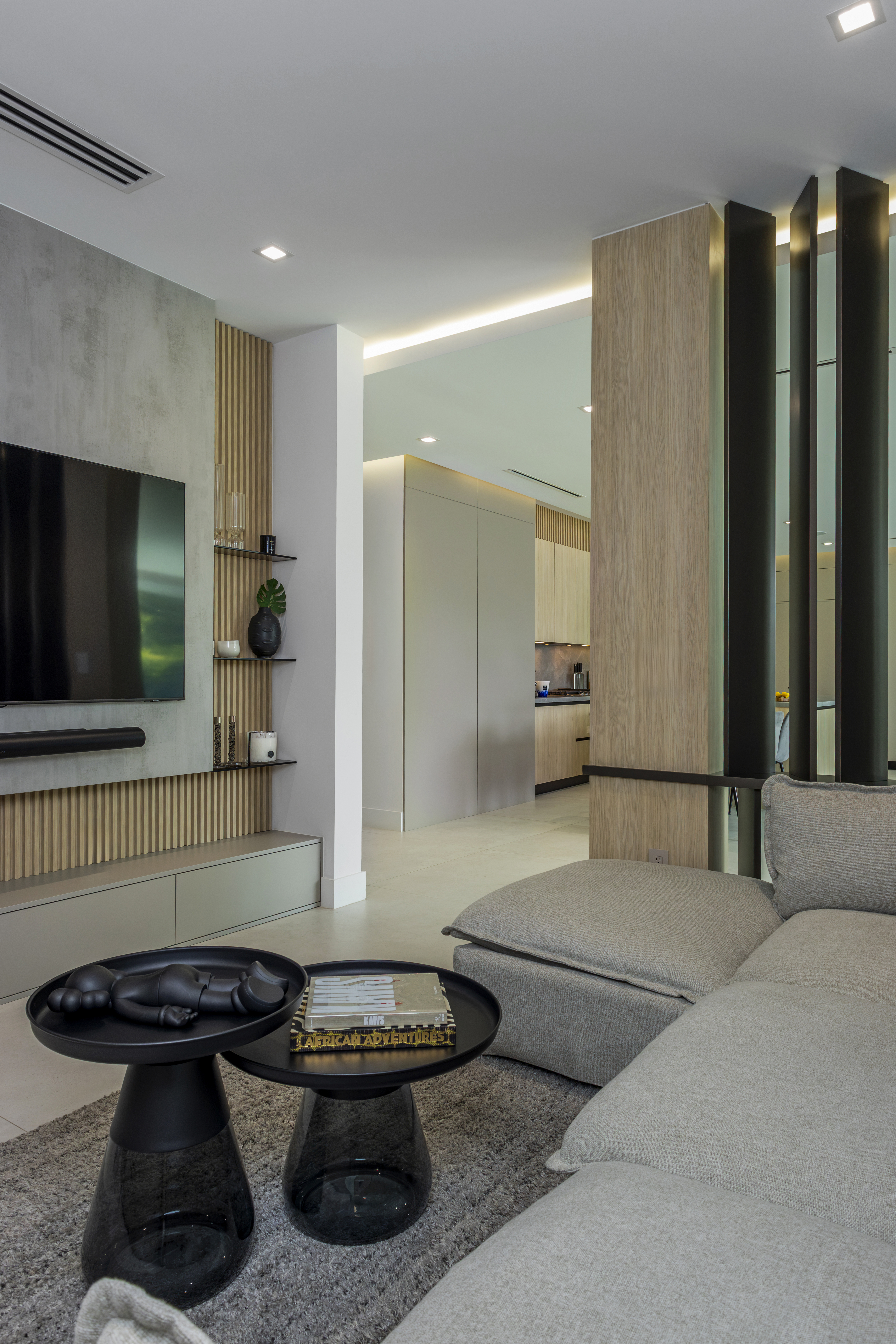 Family room — sofa with TV wall and kitchen view beyond