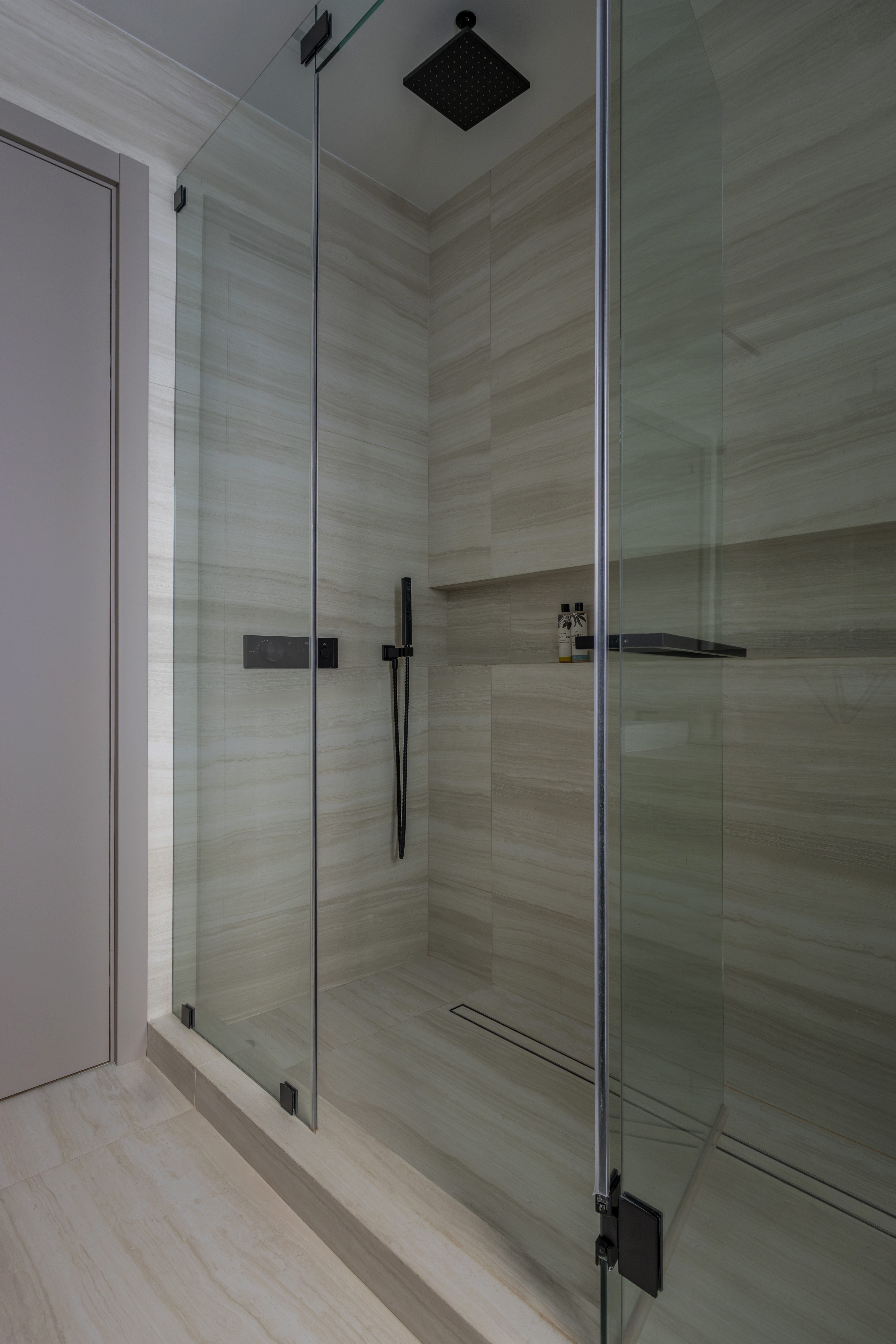 Master bathroom — frameless glass shower with rain head and black fixtures