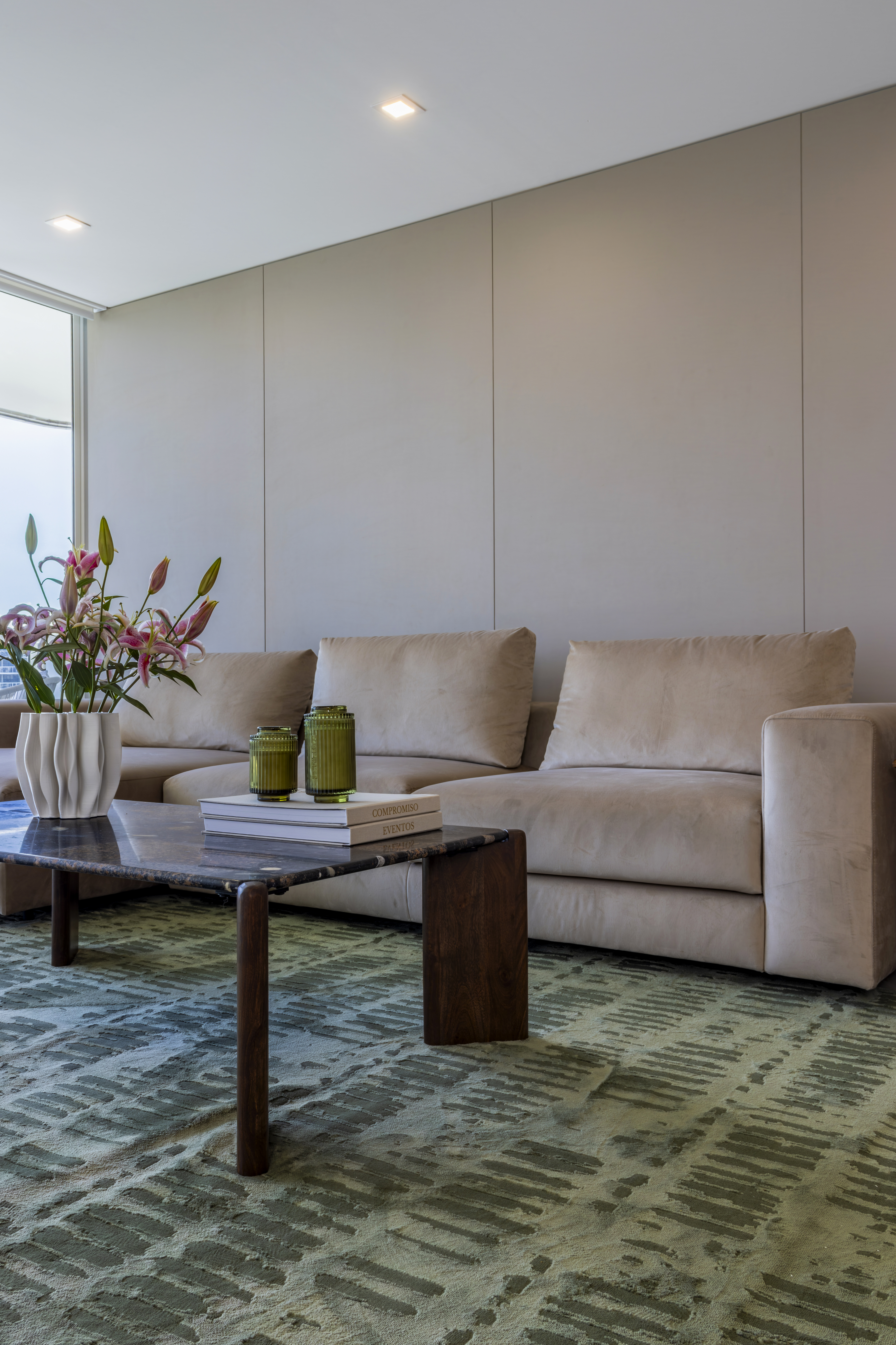 Living room — beige sofa and marble coffee table with green glassware