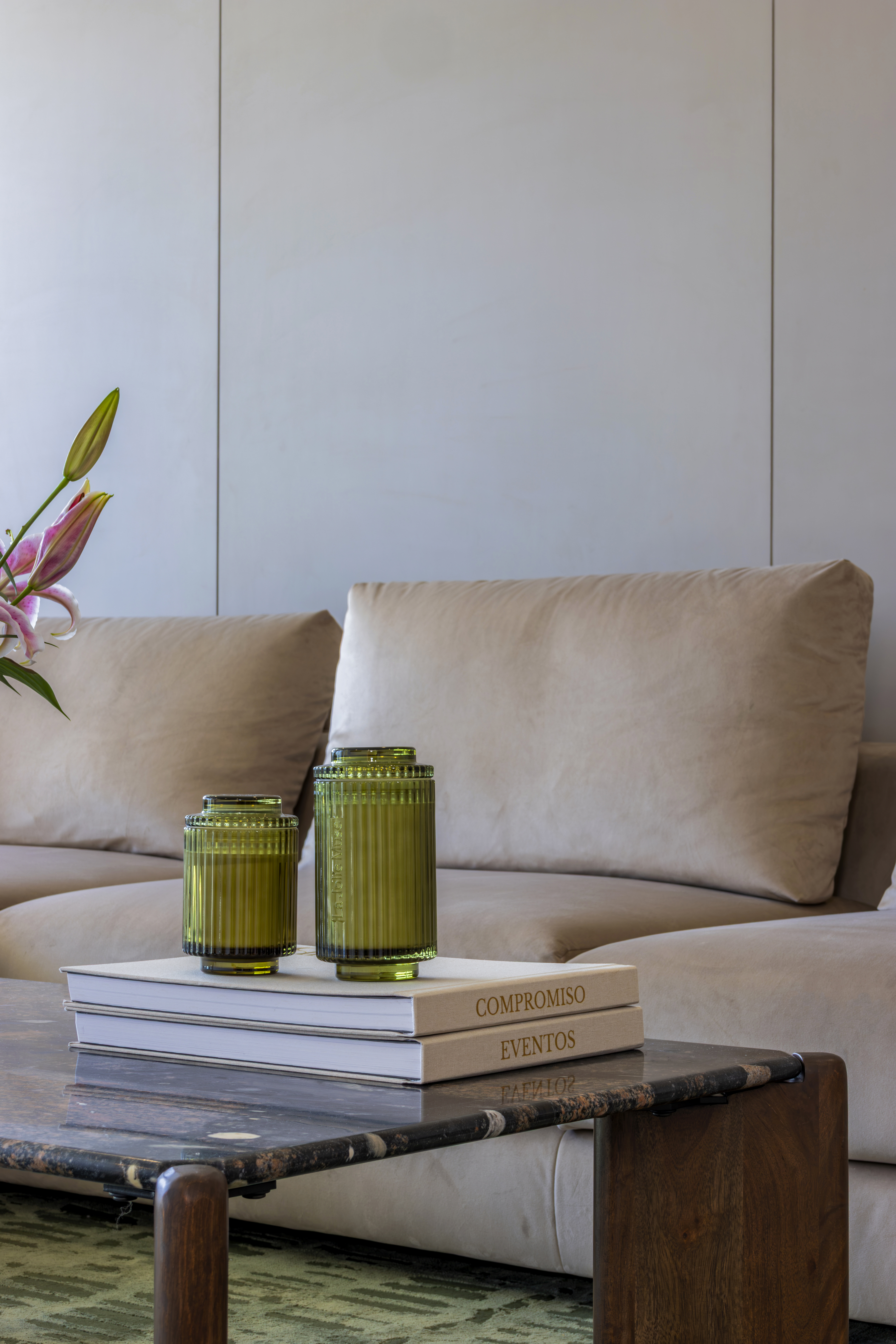 Coffee table detail — stacked books and ribbed green vessels