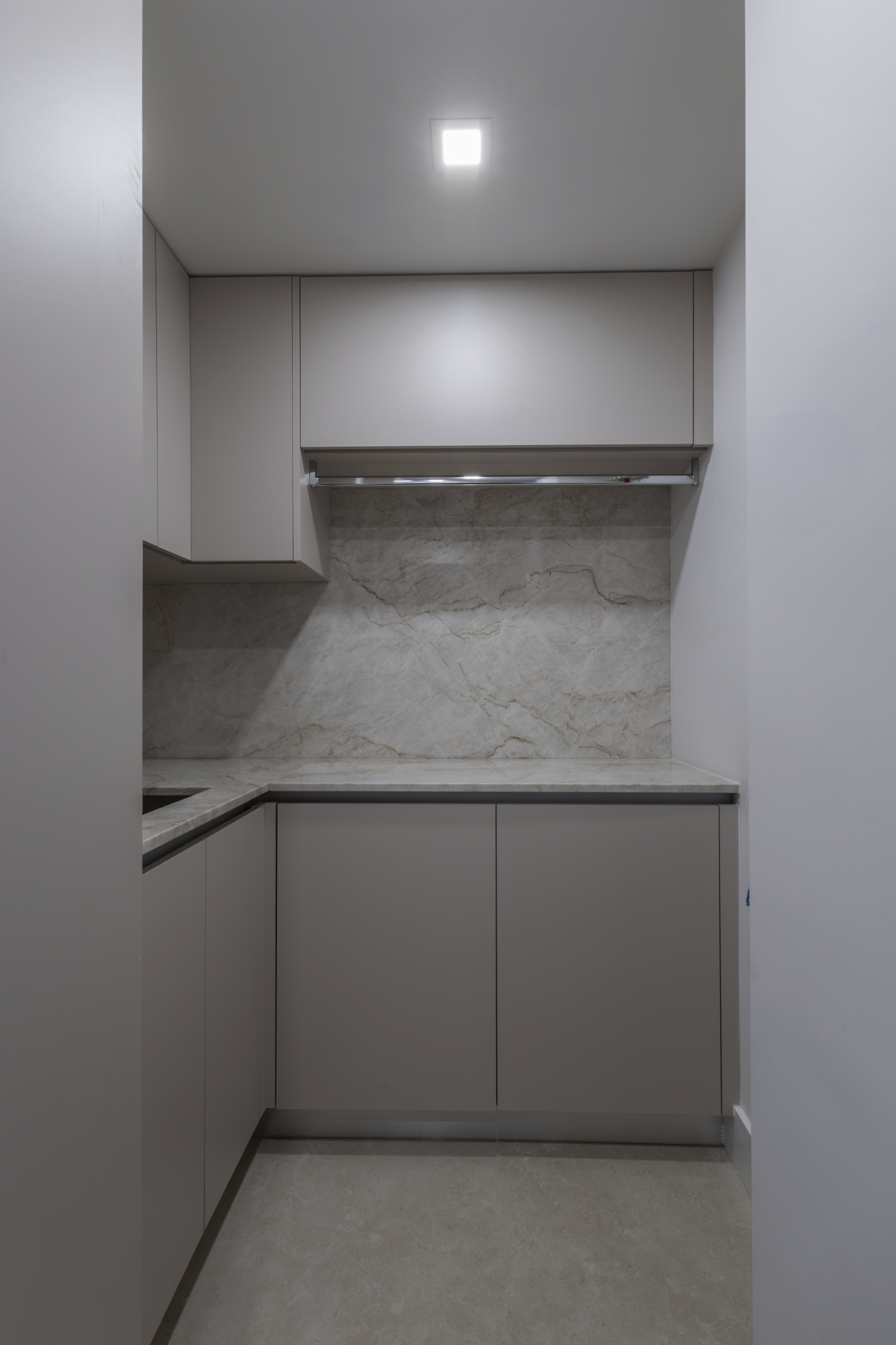 Service kitchen — taupe cabinetry with marble slab backsplash