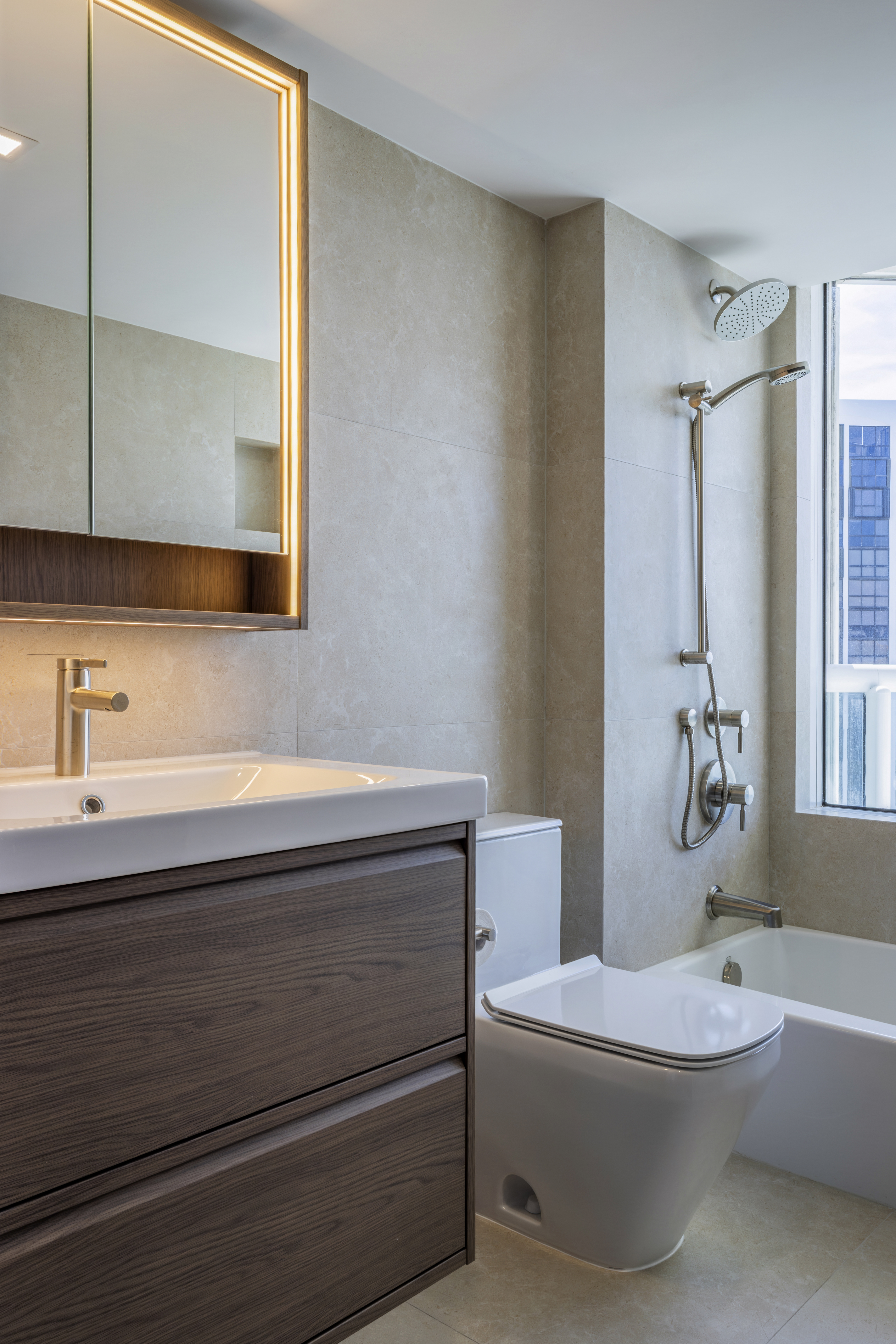 Secondary bathroom — walnut vanity with backlit mirror and tub-shower