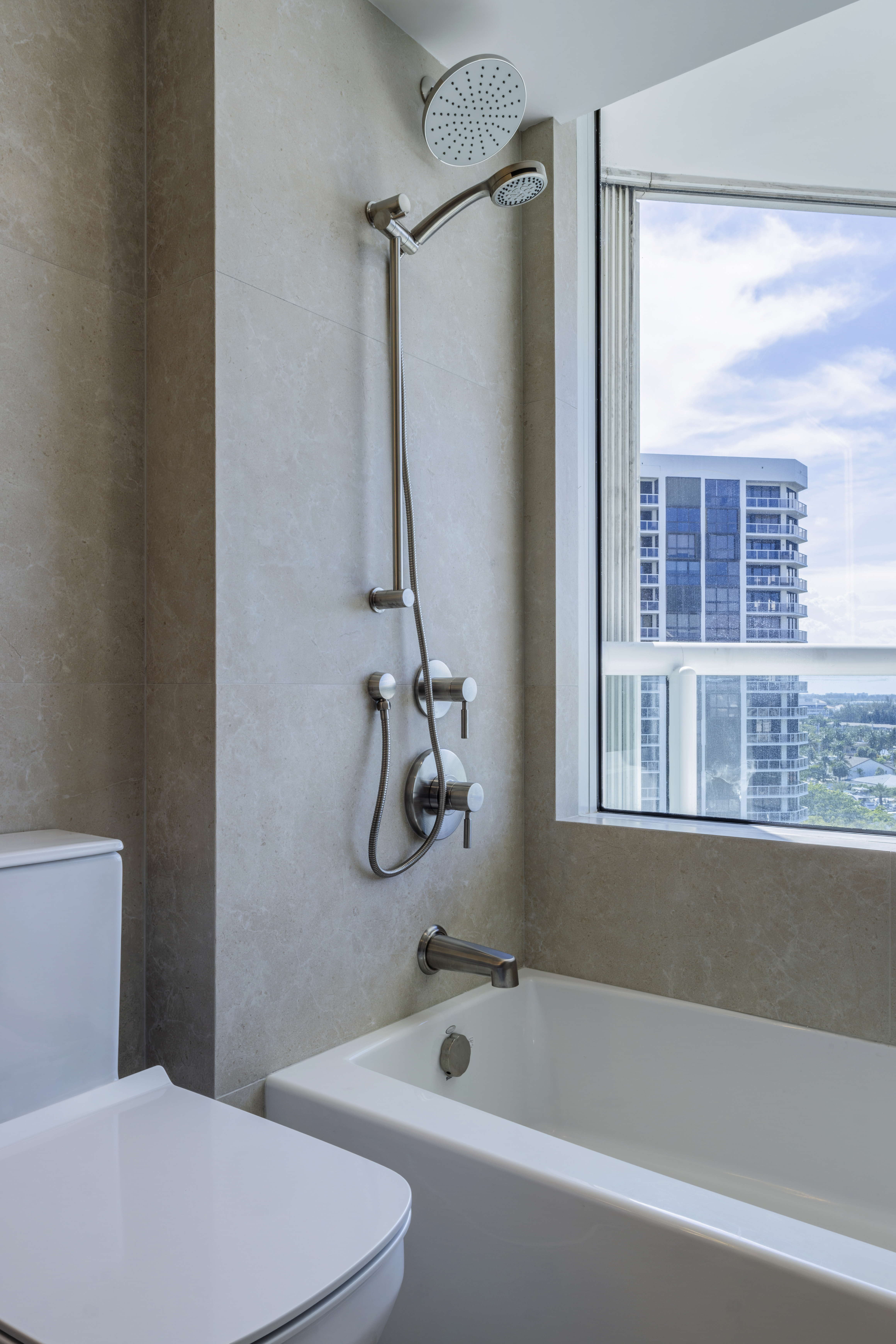 Tub-shower detail with city skyline view through window