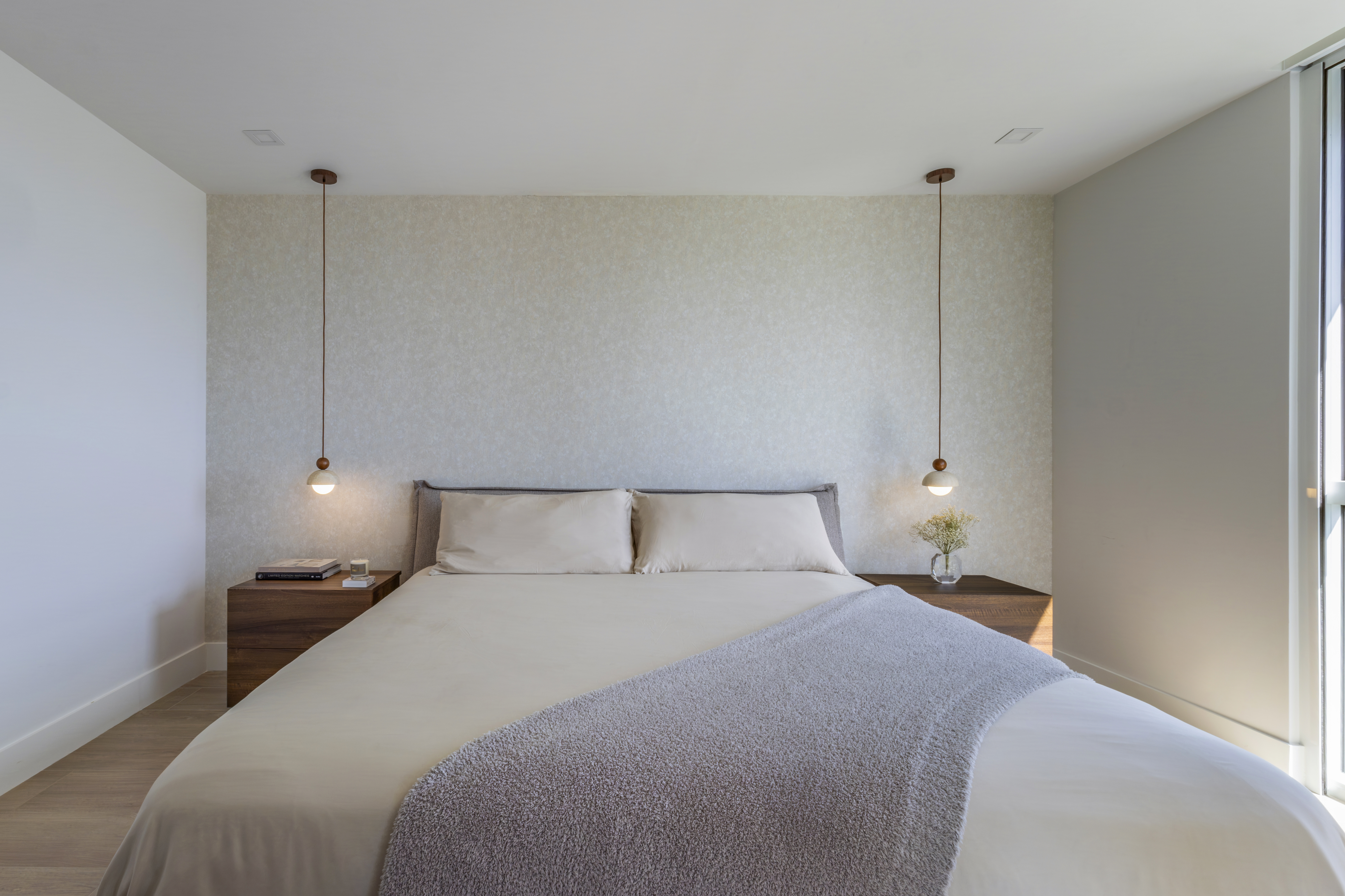 Master bedroom — upholstered headboard wall with pendant lights