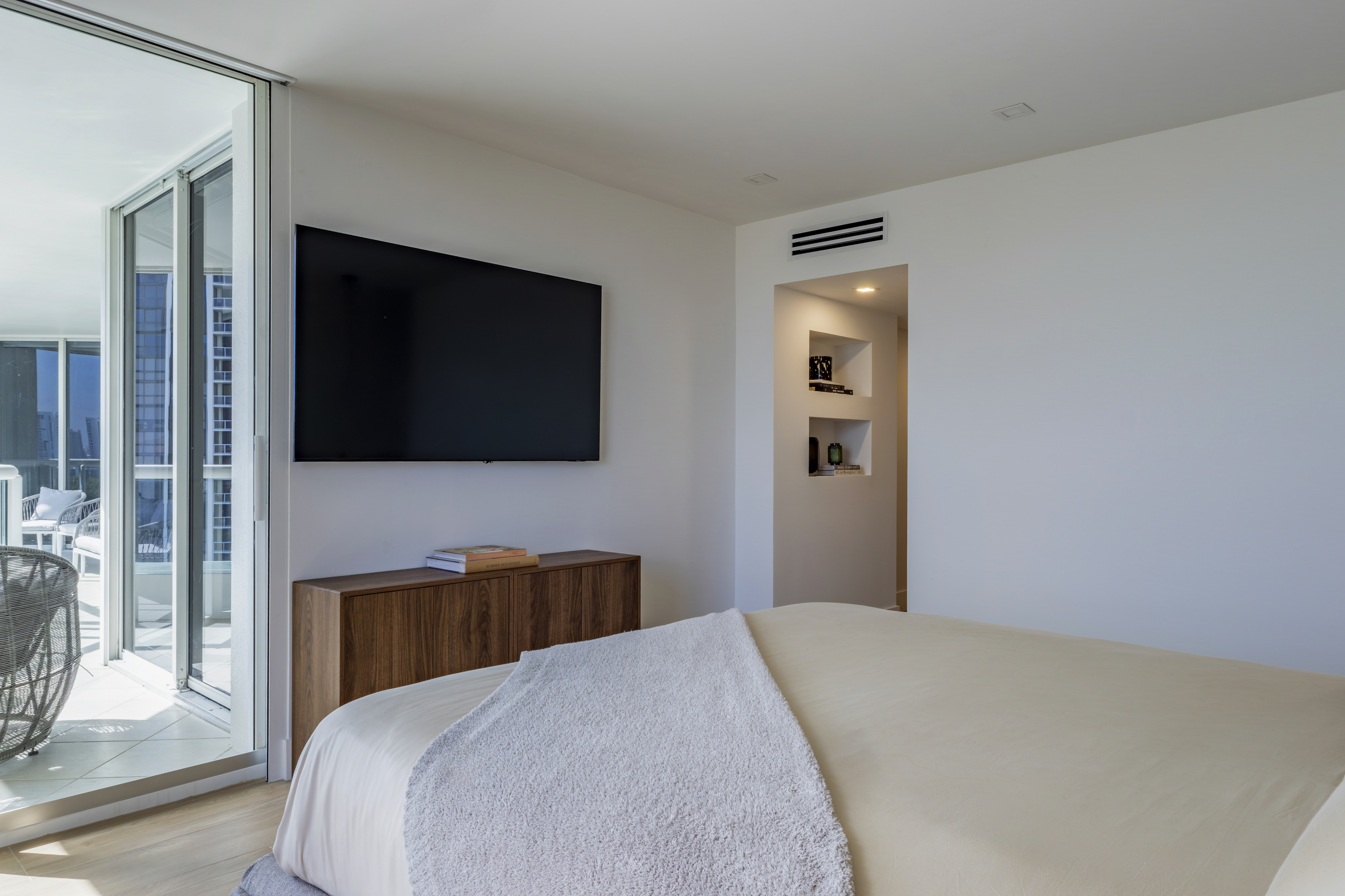Master bedroom — wide view with balcony access and city light