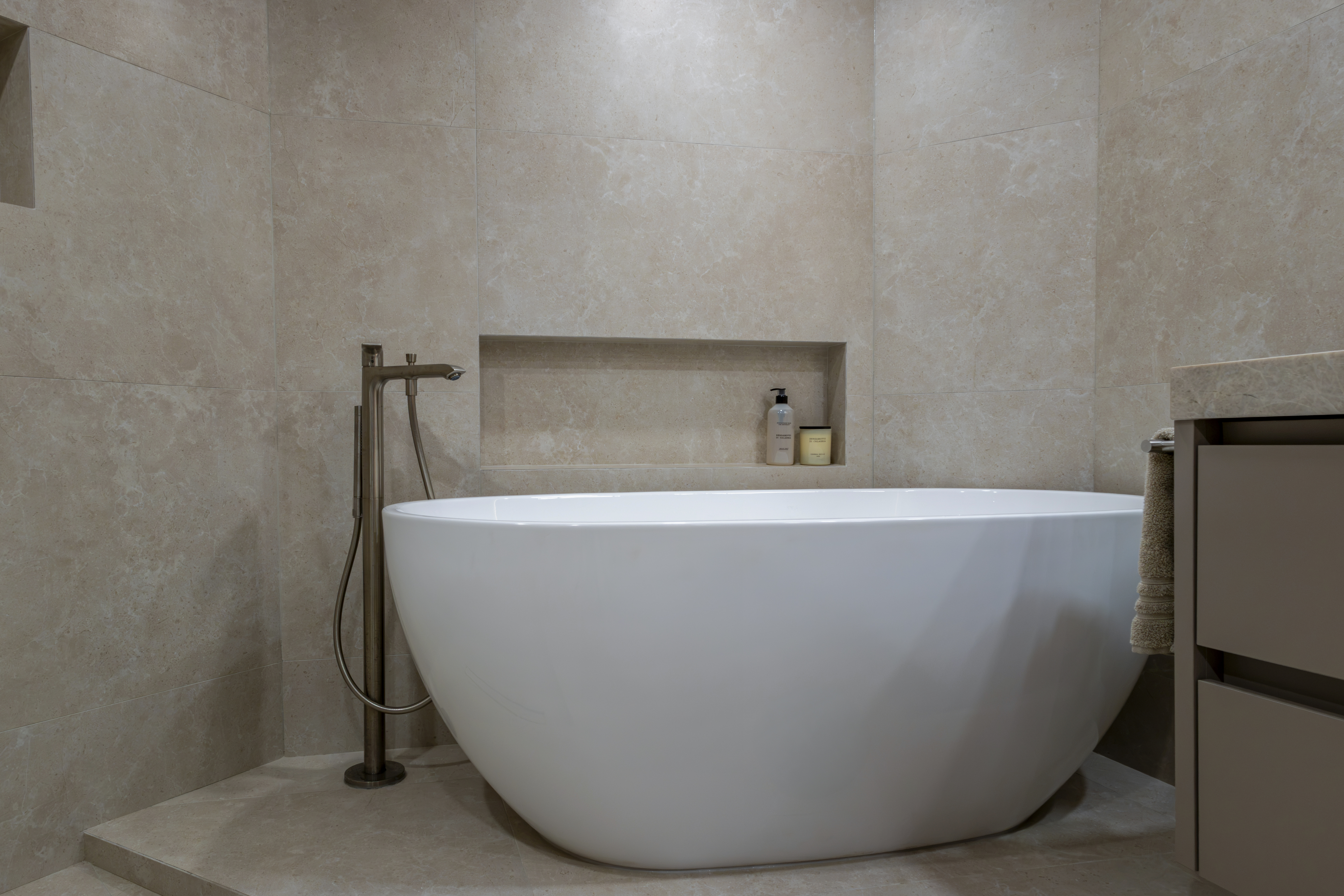 Freestanding soaking tub with stone tile walls