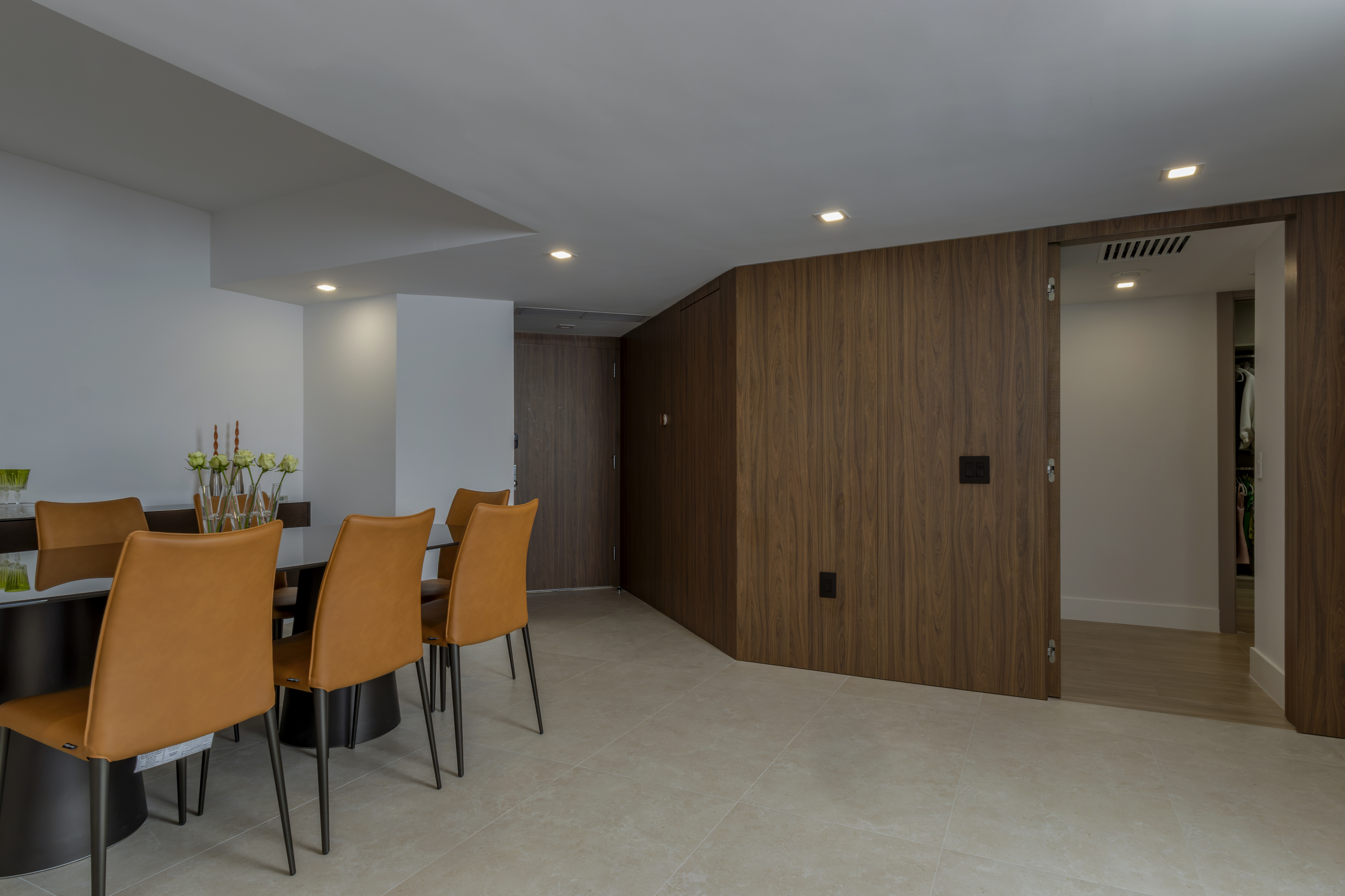 Dining area and walnut panel wall with open door