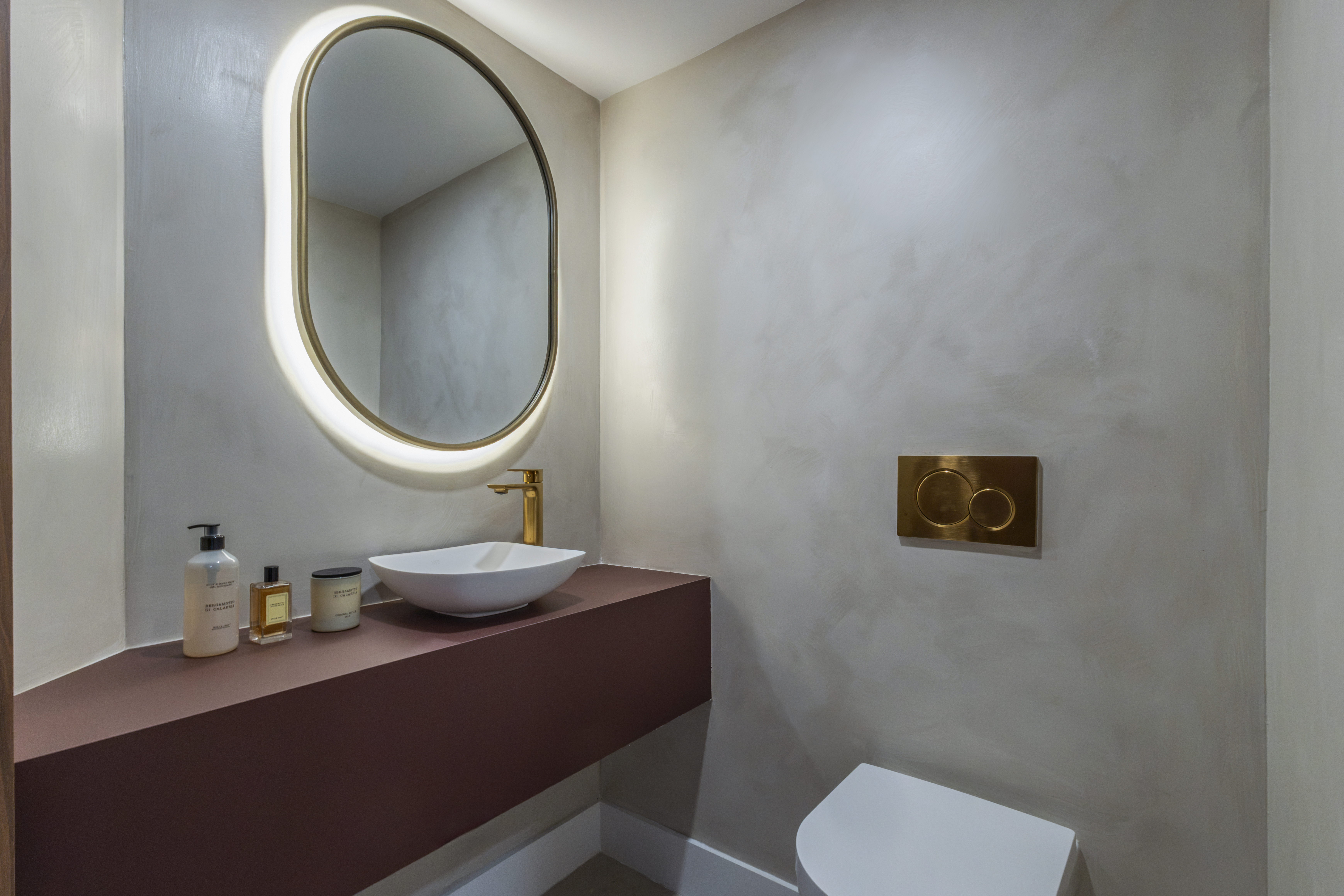 Powder room — full view with mauve vanity and oval mirror