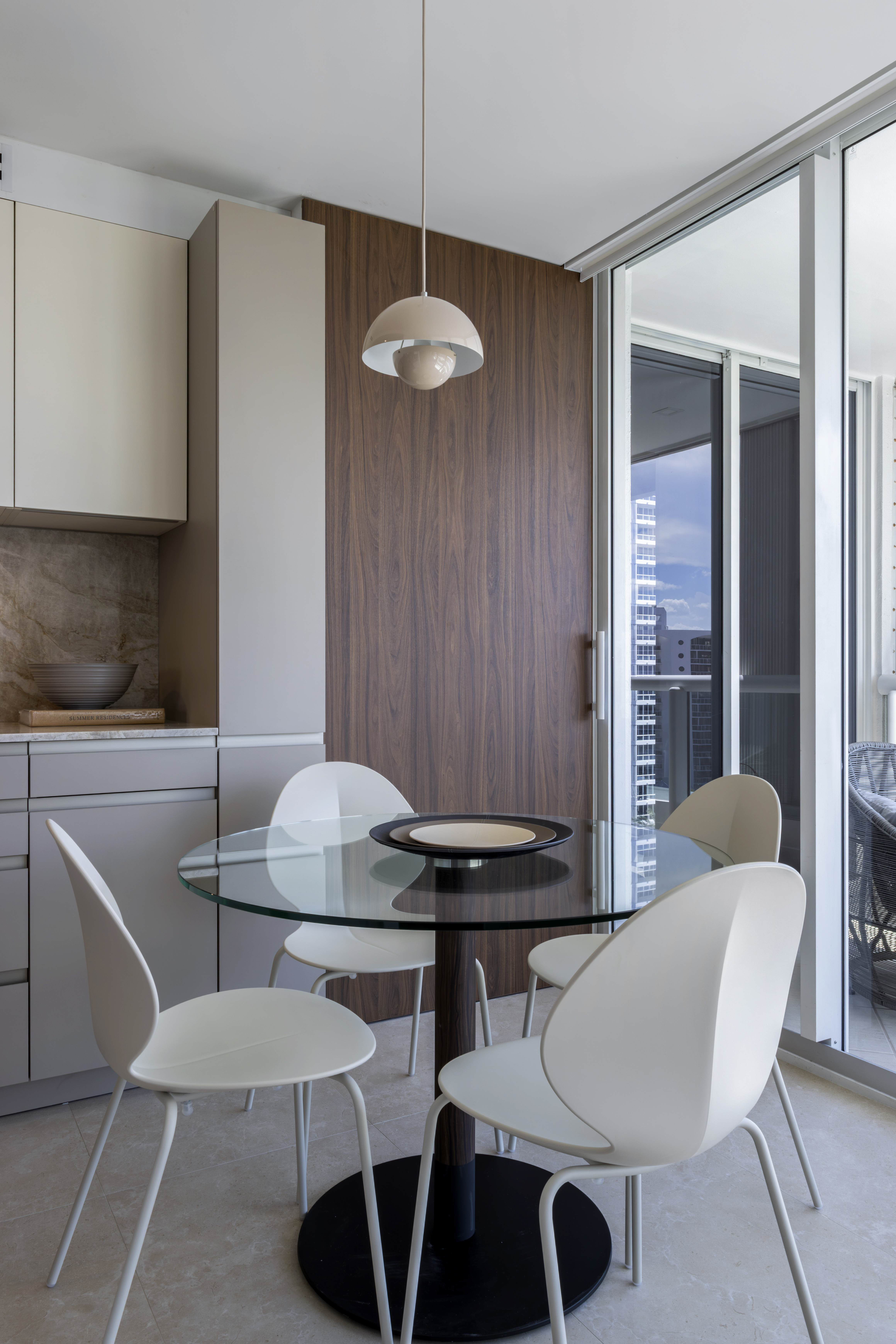 Breakfast table — glass round top with white chairs and walnut panel