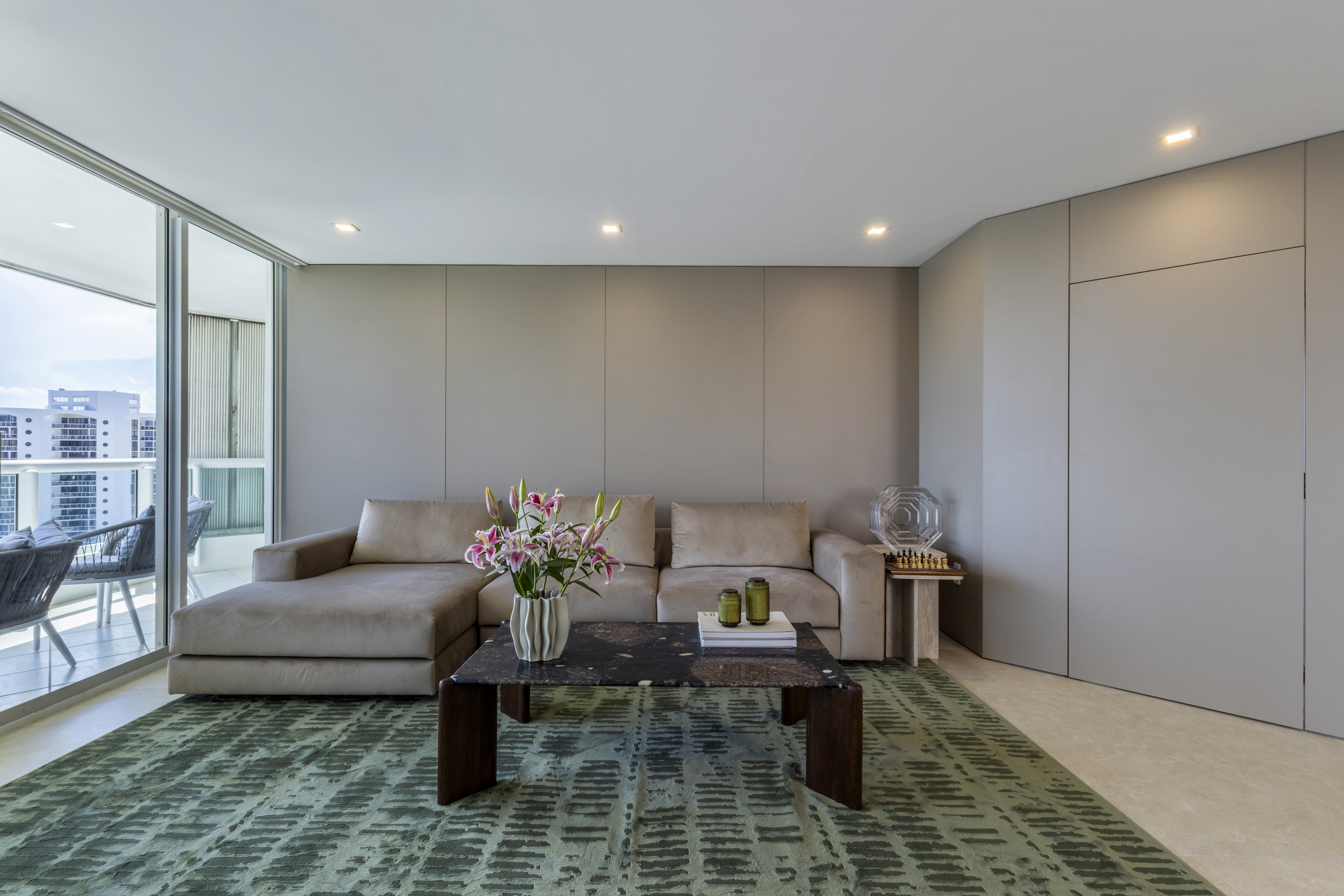 Living room — full view with balcony, panel wall and chess side table